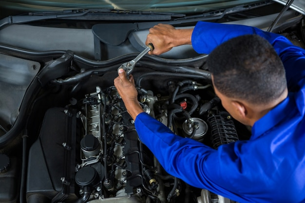 A car engine is being repaired at an auto repair shop.